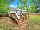 Large backyard with a wooden deck, steps, and a wooden privacy fence at 919 Edgemont Ave, Belmont, NC 28012