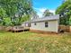 View of the house from the backyard, showing a large grassy area and a wooden deck at 919 Edgemont Ave, Belmont, NC 28012