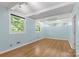 Light blue bedroom with hardwood floors and multiple windows at 640 Davie Ave, Statesville, NC 28677