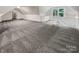 Spacious bonus room with carpet, a wet bar, and a view of the woods at 138 Bufflehead Dr, Mooresville, NC 28117