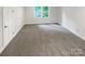 Bright bedroom with gray carpet and a window overlooking trees at 138 Bufflehead Dr, Mooresville, NC 28117