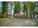 Lakefront cottage with a gravel driveway and mature trees at 192 Clearview Point Dr, Mount Gilead, NC 27306