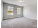 Spacious bedroom with neutral walls, carpet flooring, and two windows at 2024 Cedar Falls Dr # 9, Waxhaw, NC 28173