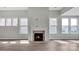 Living room with fireplace and large windows offering natural light at 9837 Jubilee Ct, Charlotte, NC 28215