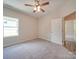 Bedroom with ceiling fan, carpet, and a view of the backyard at 253 Franklin Nw Ave, Concord, NC 28025