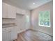Bright kitchen with white cabinets, granite counters, and wood-look floors at 253 Franklin Nw Ave, Concord, NC 28025