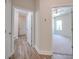 Hallway with light wood laminate flooring and access to bedrooms and a bathroom at 253 Franklin Nw Ave, Concord, NC 28025