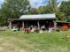 Rustic outbuilding with covered porch and various items at 1089 Cedar Springs Rd, York, SC 29745