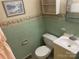 Bathroom with light green tile, vanity, and toilet at 307 Eddleman Rd, Kannapolis, NC 28083