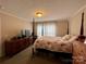 Spacious bedroom with a post bed, dresser, and window coverings at 5401 Stevens Mill Rd, Matthews, NC 28104