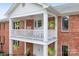 Brick house with a white balcony featuring rocking chairs at 4299 Randleman Rd, Iron Station, NC 28080