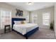 Spacious bedroom with a blue upholstered bed and large windows at 2220 Camalier Ln, Charlotte, NC 28273