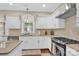 Modern kitchen with white cabinets, granite countertops, and gas range at 8534 Headford Rd, Charlotte, NC 28277