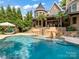 Luxury pool with waterfall feature; adjacent to a stone patio and charming home at 14009 Island Dr, Huntersville, NC 28078