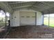 White carport with attached garage door and gravel floor at 115 Sunrise Cir, Shelby, NC 28150