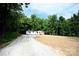 Gravel driveway leads to a white manufactured home nestled in a wooded area at 2574 Orchard Rd, Smyrna, SC 29743
