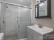Modern bathroom with gray vanity and tiled shower at 1021 Wall St, Statesville, NC 28677