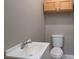 Clean bathroom with a toilet, sink, and overhead cabinet at 1021 Wall St, Statesville, NC 28677