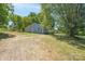 Gray house exterior with a gravel driveway and mature trees at 1021 Wall St, Statesville, NC 28677