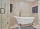 Bathroom featuring a clawfoot tub and marble tile at 6639 Ronda Ave, Charlotte, NC 28211