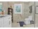 Modern bathroom with a toilet, shower, and stylish shelving at 6639 Ronda Ave, Charlotte, NC 28211