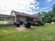 Large backyard patio with built-in grill and seating area, attached to deck and carport at 213 Press Sweezy Rd, Kings Mountain, NC 28086