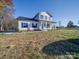 Two-story farmhouse with white siding, black windows, and a covered porch at 9403 E Nc 218 Hwy, Peachland, NC 28133