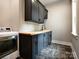 Laundry room with dark cabinetry, wood countertop and herringbone tile floor at 205 Water Oak Way, Mount Gilead, NC 27306