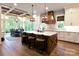 Open concept kitchen with white cabinets, island, and wooden beams at 205 Water Oak Way, Mount Gilead, NC 27306