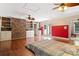Main bedroom with hardwood floors, brick accent wall, and access to deck at 1099 4Th Avenue Nw Dr, Hickory, NC 28601
