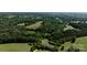 Aerial view of a property featuring a pond and lush forest, ideal for nature lovers at 3219 Mount Pleasant N Rd, Concord, NC 28025