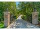 Long driveway entrance with brick pillars and a wrought-iron gate at 1008 Medinah Ct, Waxhaw, NC 28173