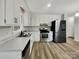 Modern kitchen featuring white cabinets, stainless steel appliances, and vinyl flooring at 2008 Sarn Ct, Gastonia, NC 28054