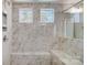 Walk-in shower with marble tile and two windows for natural light at 5312 Verona Rd # 74, Charlotte, NC 28213