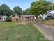 Ranch-style home with red siding and a gravel driveway at 1819 Danbury St, Gastonia, NC 28052