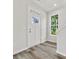 Bright entryway with white door, wood-look floors, and stairway at 1008 Ribbon Ln, Charlotte, NC 28205
