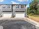 Rear view of townhouses with gray siding and garage doors at 1008 Ribbon Ln, Charlotte, NC 28205