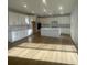 Bright, spacious kitchen featuring white cabinetry, an island, and wood-look flooring at 104 Goorawing Ln, Mooresville, NC 28115