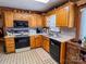 Kitchen with oak cabinets, black appliances, and a breakfast bar at 1470 River Hills Ct, Taylorsville, NC 28681