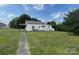 Side view of a small house needing repairs, with a grassy yard at 1900 Salome Church Rd, Charlotte, NC 28262