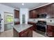 Kitchen with dark wood cabinets, granite countertops, and stainless steel appliances at 1013 Taylor Glenn Ln, Indian Trail, NC 28079