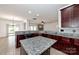 Open kitchen boasts granite countertops, dark wood cabinets, and an island at 1013 Taylor Glenn Ln, Indian Trail, NC 28079