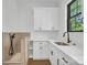 Bright laundry room with white cabinets, quartz countertops, and a utility sink at 1106 Anniston Pl # 51, Indian Trail, NC 28079