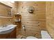 Simple bathroom with wood walls, sink, and toilet at 7230 Timber Ridge Dr, Mint Hill, NC 28227