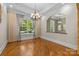 Elegant dining room with hardwood floors, large window, and chandelier at 7230 Timber Ridge Dr, Mint Hill, NC 28227