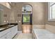 Elegant bathroom with double vanity, soaking tub, and access to bedroom at 7230 Timber Ridge Dr, Mint Hill, NC 28227