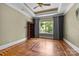 Bright bedroom with hardwood floors, large window, and built-in bookcase at 7230 Timber Ridge Dr, Mint Hill, NC 28227