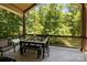 Covered deck with wooded views and outdoor dining set at 7230 Timber Ridge Dr, Mint Hill, NC 28227