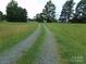 Gravel driveway leading to a house in a rural setting at 14004 Elm St, Stanfield, NC 28163