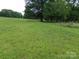 Open grassy lot with mature trees and natural landscaping at 14004 Elm St, Stanfield, NC 28163